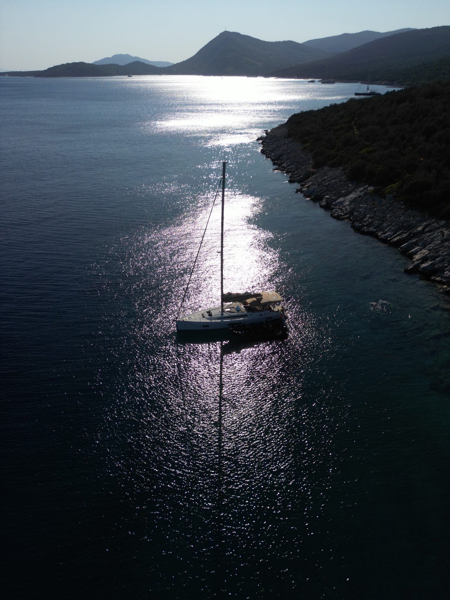 Backlit evening light, the sea like beaten silver